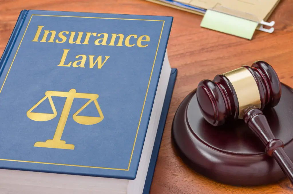 A law book titled Insurance Law with a gavel